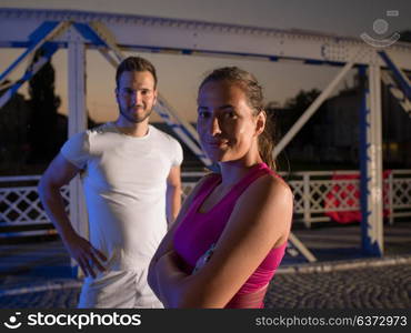 urban sports, portrait of a healthy couple jogging across the bridge in the city at early morning in night