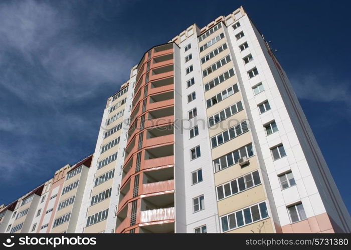 Urban view at modern glass building with reflection on blue sky