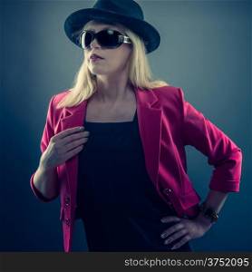 Urbane mature woman wearing a sunglasses and hat, studio shot