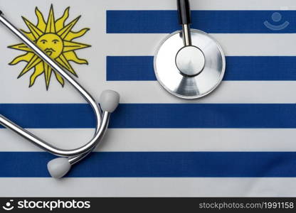 Uruguay flag and stethoscope. The concept of medicine. Stethoscope on the flag in the background.. Uruguay flag and stethoscope. The concept of medicine.