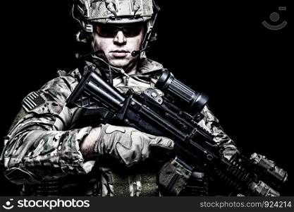 US army soldier, marine rider, special forces fighter in combat uniform, helmet and glasses, radio headset, armed assault rifle with night vision, thermal imagining, optical sight on black background. US army soldier with rifle on black background