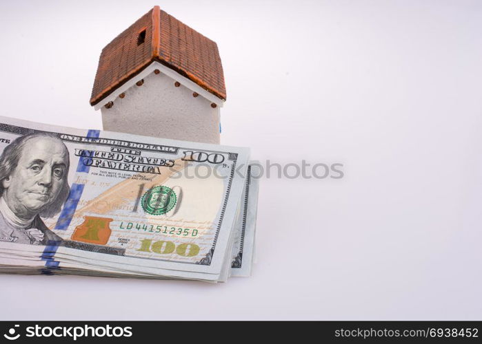 US Dollar banknotes by the side of a model house