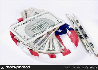 US dollar bills with an American flag and pencils