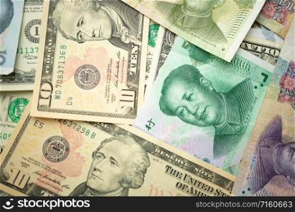 US dollar stack and Chinese yuan banknotes on the table The concept of a trade war between the United States and China
