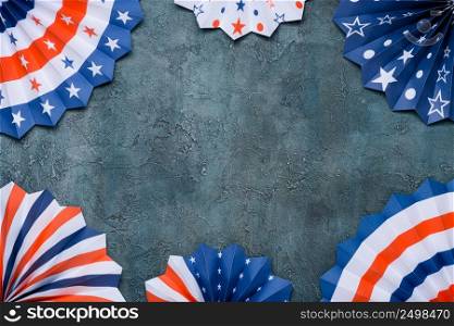 US flag colored paper star fans. 4th of July USA flag theme paper fans on rustic stucco background.