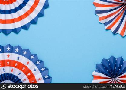 US flag colored paper star fans on blue background.
