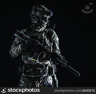 US marine riders shooter, army special forces soldier standing in darkness in mask, battle uniform, quad-tube, four lenses night vision goggles on helmet, low key, side view, studio portrait on black. Marine rider with night vision goggles portrait