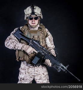 US marine with his assault rifle on black background