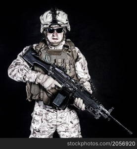 US marine with his assault rifle on black background