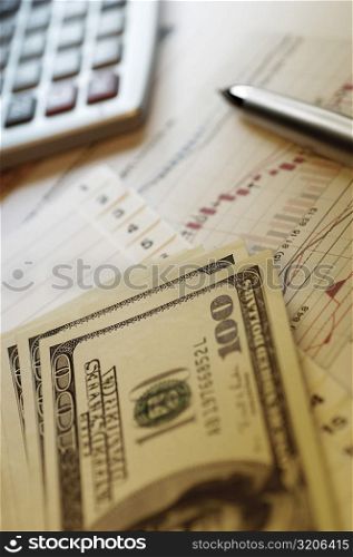 US paper currency and pen with a personal organizer on a bargraph