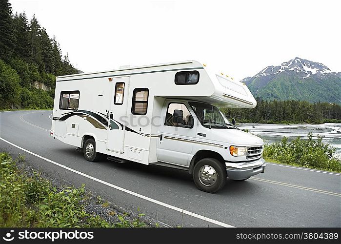 USA, Alaska, recreational vehicle driving on road, side view