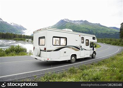 USA, Alaska, recreational vehicle driving on road, side view