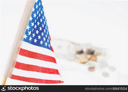USA flag, stack of coins and dollors in background, selective focus. Travel America concept