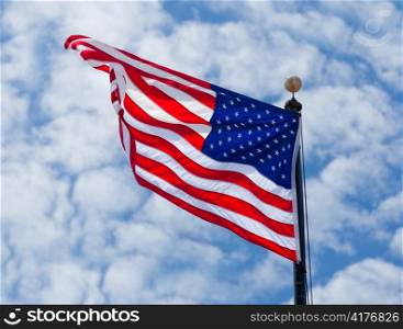 USA flag waving on the wind on cloudy sky background