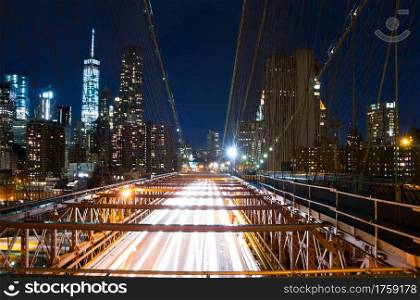 USA. New York City. Night Brooklyn bridge. View of the traffic on the bridge and the skyscrapers of Manhattan. Brooklyn Bridge at Night
