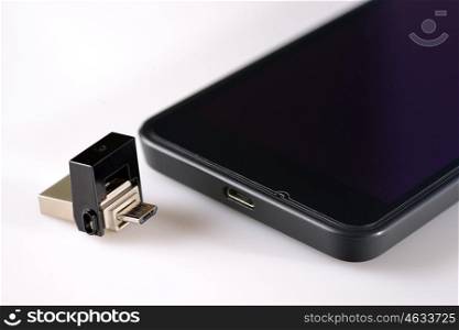 USB flash drive and smartphone on white table