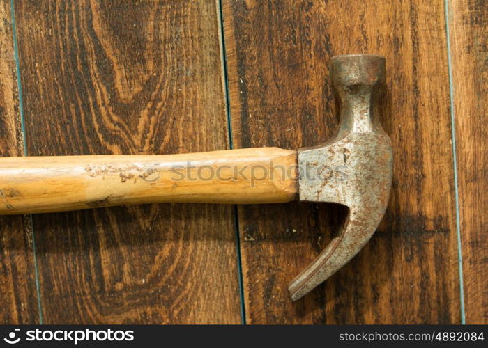Used and rusty hammer on a wooden background