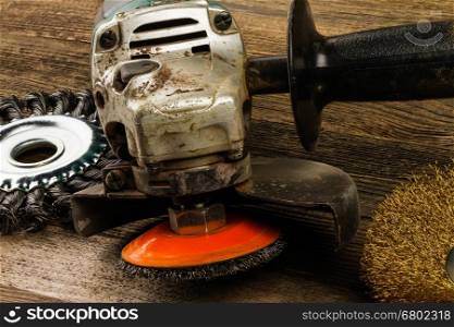used grinding machine with worn and new metal brushes on wooden background