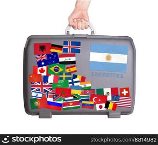 Used plastic suitcase with lots of small stickers, large sticker of Argentina