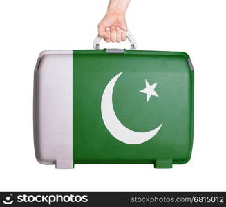 Used plastic suitcase with stains and scratches, printed with flag, Pakistan