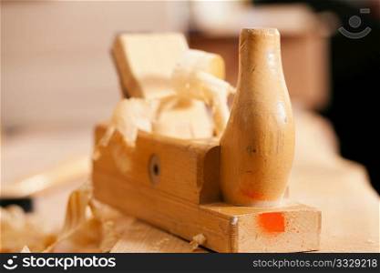 Used wood planer in the workshop of a carpenter with shavings of wood, standing on a workbench