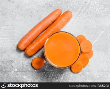 Useful carrot juice in a glass. On rustic background. Useful carrot juice in a glass.