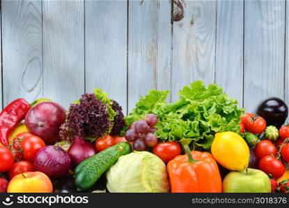 Useful vegetables and fruits on light blue wooden wall background. Healthy foods.
