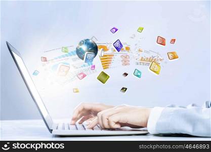 Using laptop. Close up image of laptop and human hands typing on keyboard. Elements of this image are furnished by NASA