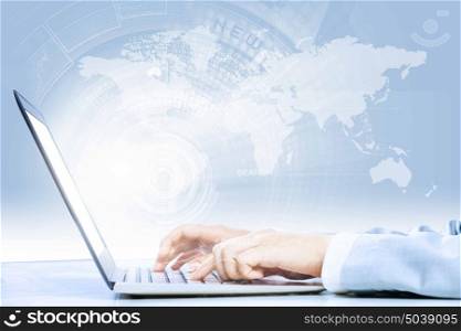 Using laptop. Close up image of laptop and human hands typing on keyboard