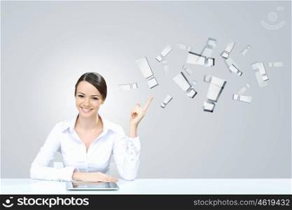 Using modern technologies. Attractive businesswoman sitting at table and using tablet