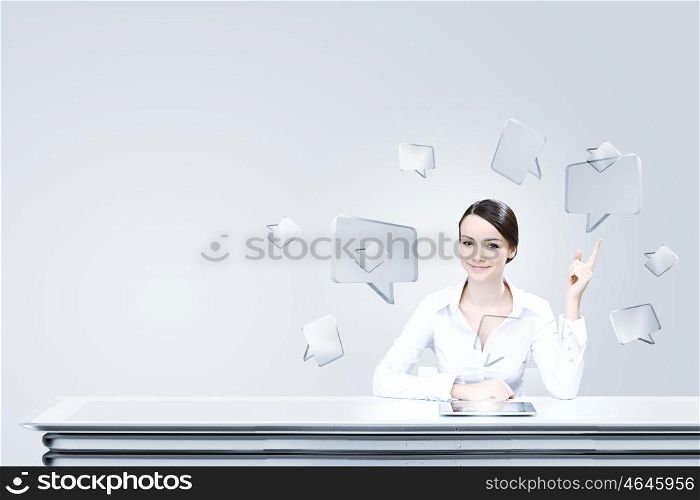 Using modern technologies. Attractive businesswoman sitting at table and using tablet