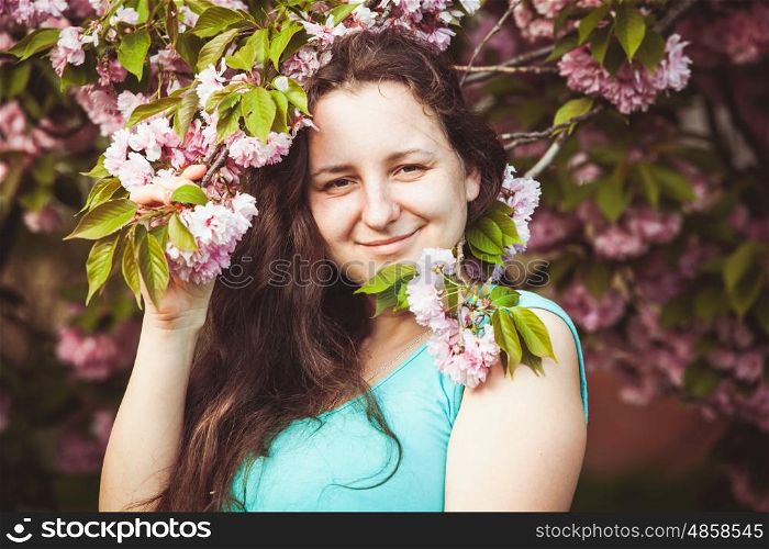 Usual happy woman portrain in the sakura blooming. Usual happy woman
