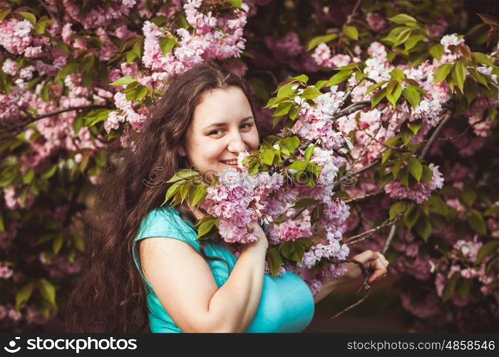 Usual happy woman portrain in the sakura blooming. Usual happy woman