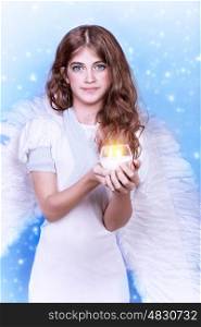 ?ute angel, portrait of beautiful teen girl wearing fluffy wings and holding in hands candle on snowing background, purity and innocence conception