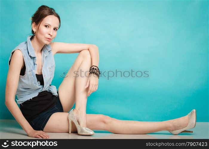 Vacation and summer fashion. Full length fashionable girl in jeans shirt shorts and high heels on blue