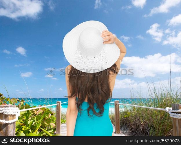 vacation and summer holidays concept - model in swimsuit with hat