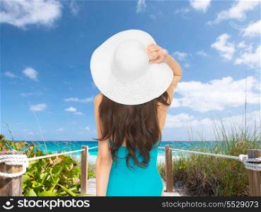 vacation and summer holidays concept - model in swimsuit with hat
