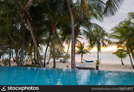 vacation, beach, summer and leisure concept - swimming pool on tropical beach