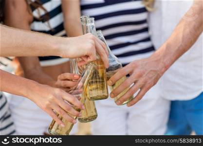 vacation, celebration, holidays and people concept - close up of hands clinking bottles with drinks at party