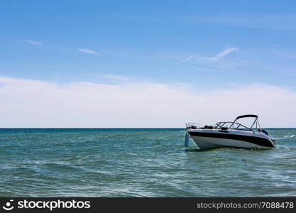 Vacation concept - empty white speed boat on seaside on blue sky background