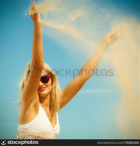 vacation happiness and freedom concept. Beautiful girl playing with sand on beach. Young woman having fun relaxing on the sea coast.