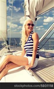 vacation, holidays, travel, sea and people concept - smiling young woman sitting on yacht deck
