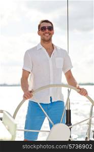 vacation, holidays, travel, sea and people concept - young man in sunglasses steering wheel on yacht