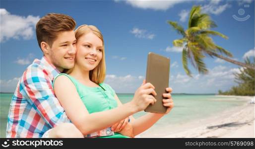 vacation, holidays, travel, technology and love concept - smiling couple with tablet pc computer taking selfie over tropical beach background