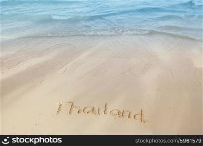 Vacation in Thailand concept. Vacation in Thailand concept - inscription on a beach sand with coming wave