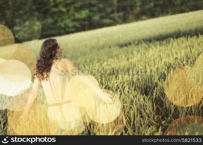 Vacation picture of the young woman among the corn crop