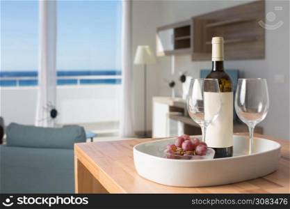vacation room with sea view and table with bottle of wine and glasses.