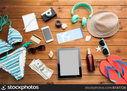 vacation, tourism, technology and objects concept - close up of tablet pc computer, smartphone and travel stuff