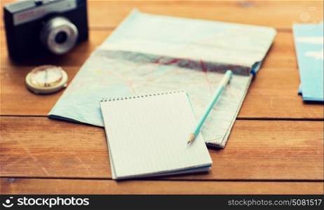 vacation, tourism, travel and objects concept - close up of blank notepad with map and airplane tickets. close up of notepad with map and travel tickets