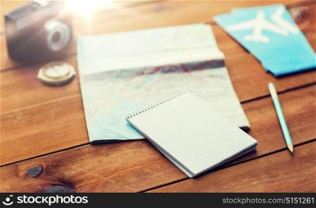 vacation, tourism, travel and objects concept - close up of blank notepad with map and airplane tickets. close up of notepad with map and travel tickets